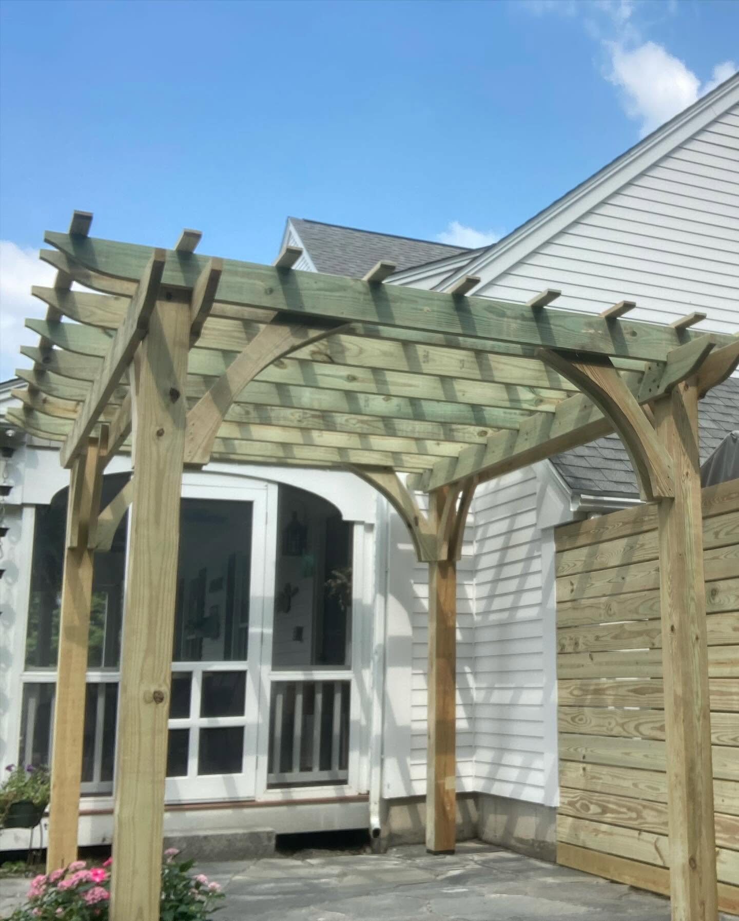 Custom-built cedar pergola off a screened porch