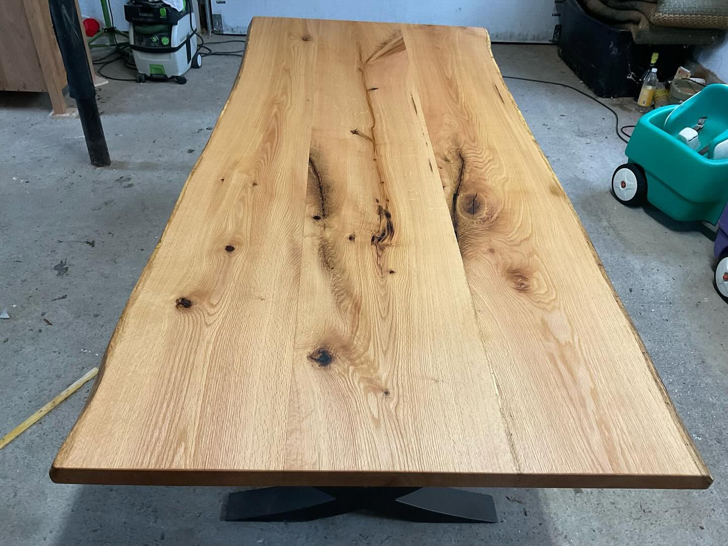 Live-edge oak dining table on a blackened steel base