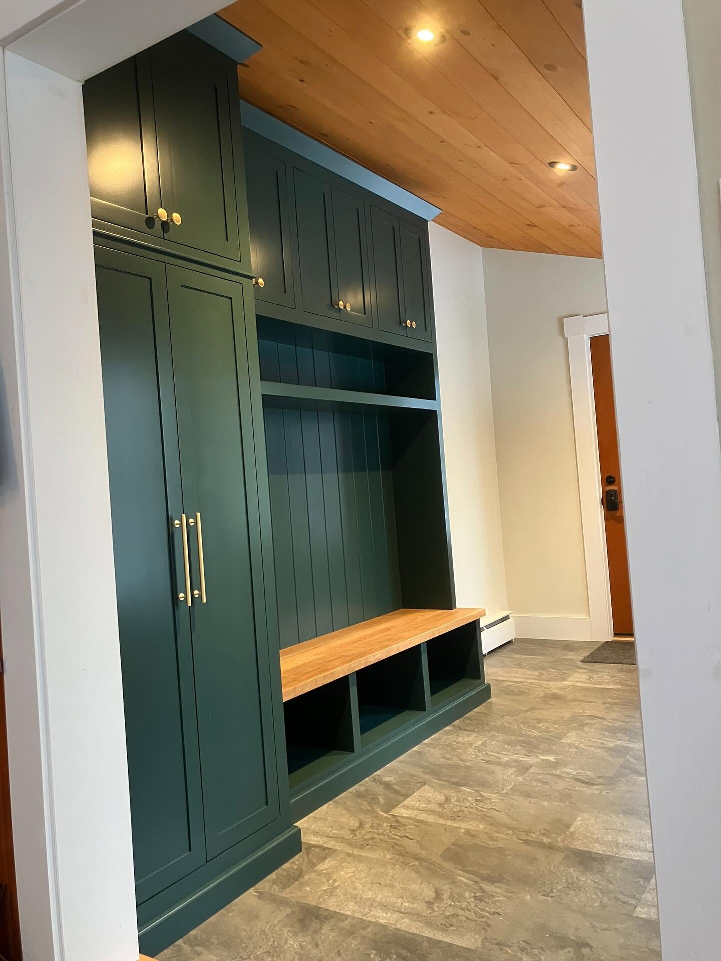 Built-in mudroom lockers and bench in deep green